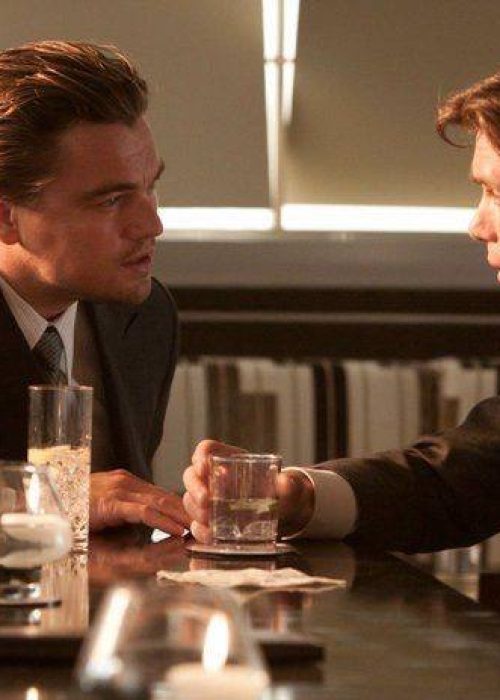 Two men in suits at bar.