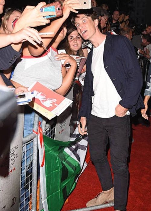 Crowd interacting at a red carpet event.